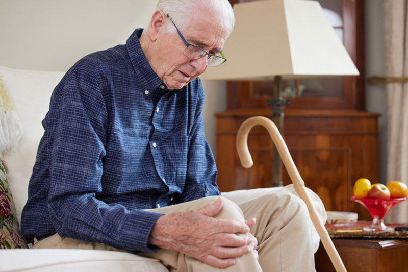 An older man thinks about questions to ask the doctor before his knee replacement surgery.
