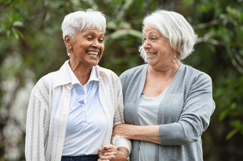 A woman takes a walk with an older loved one, following the dos and don’ts for dementia visits.