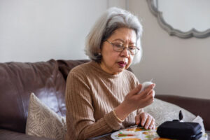 An older woman tests her blood sugar levels while contemplating care tips for diabetes management.